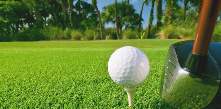 Golf ball on tee at Reunion Resort course in Kissimmee, Florida with tropical landscape